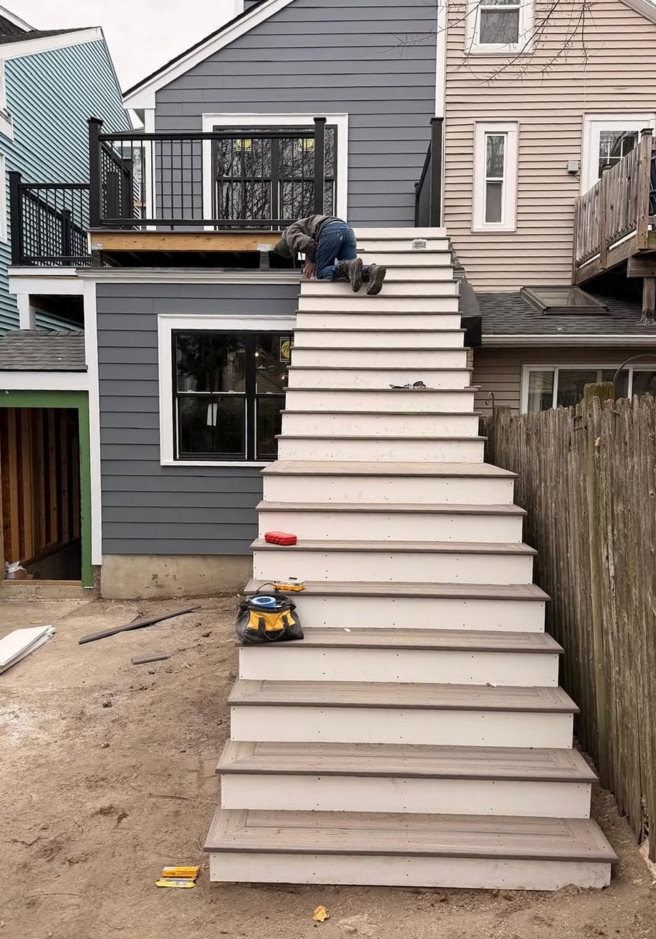 New wooden stairs leading up to a rear deck on a Massachusetts home